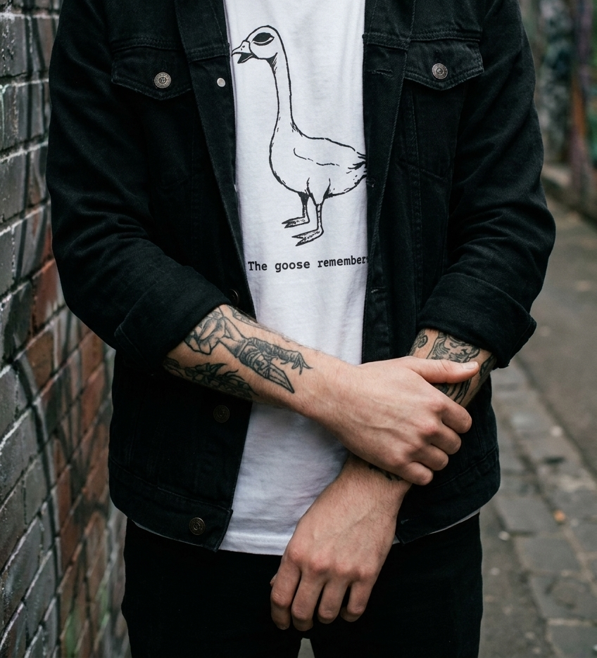 Person wearing The Goose Remembers tee in a laneway